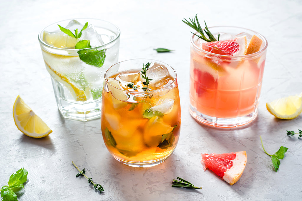 three delicious mocktails on a table with garnish