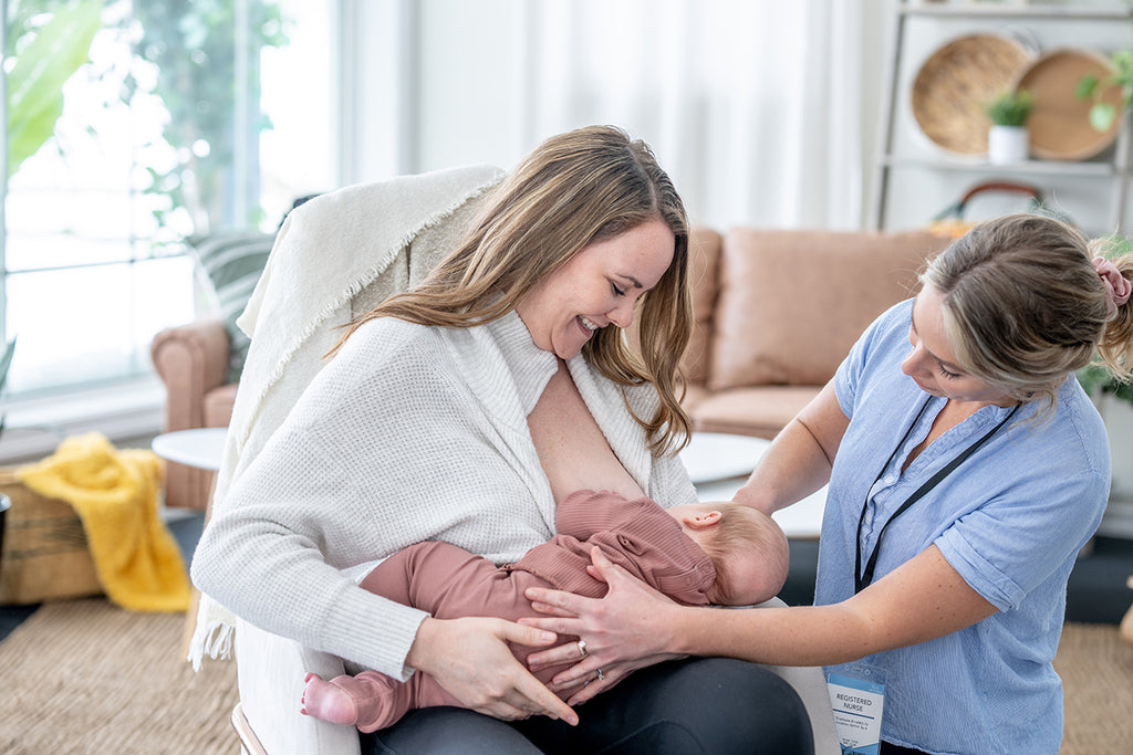 lactation nurse helping new mother breastfeed