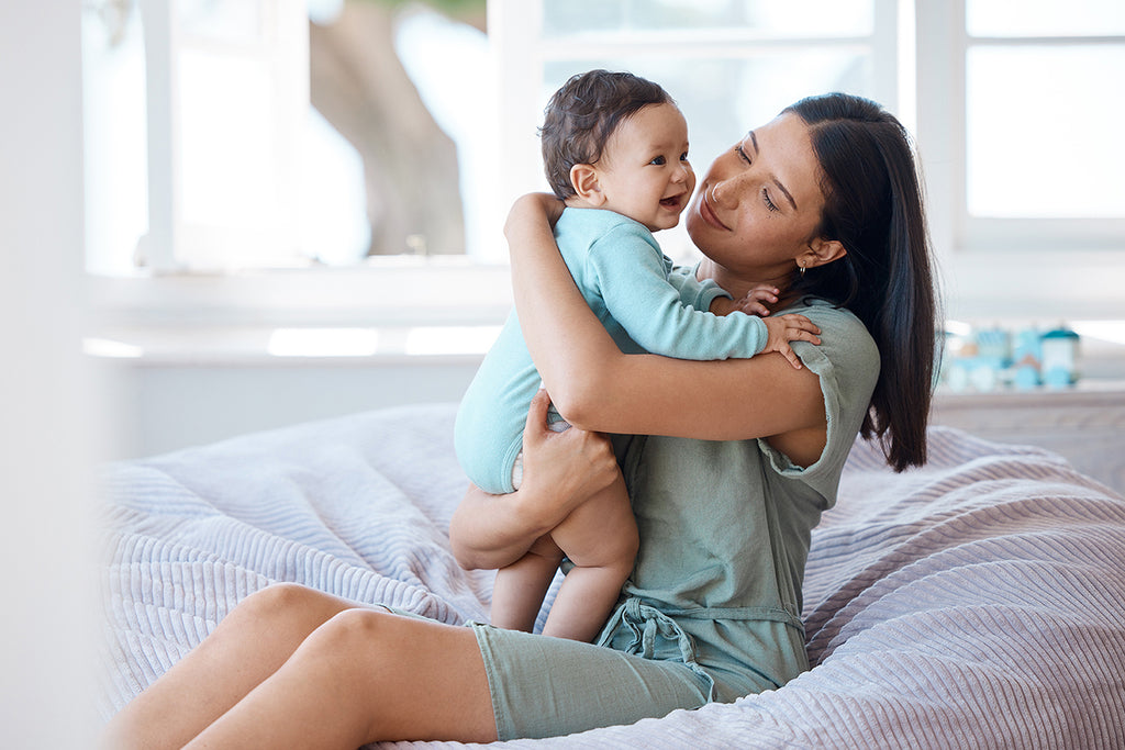 Mother holding baby in bed