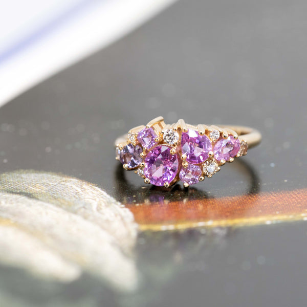 pink and purple gemstone avalanche statement ring by bena jewelry montreal on a dark background