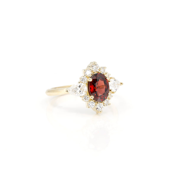 oval shape deep red garnet gemstone and lab grown diamond in yellow gold custom made in montreal on white background