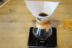 Chemex brewer with grinds in it, sitting on a scale