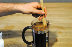 Person stirring coffee in press pot