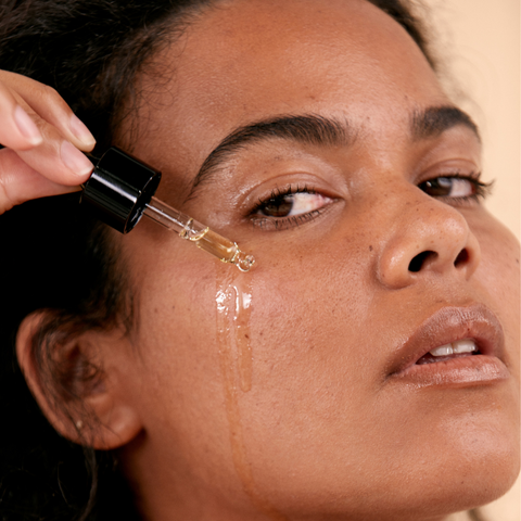 woman applying serum to face