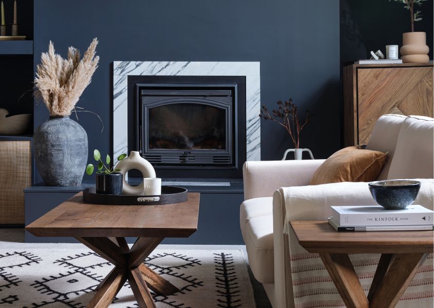 rustic coffee table in living room with dark blue feature wall and cream fabric sofa