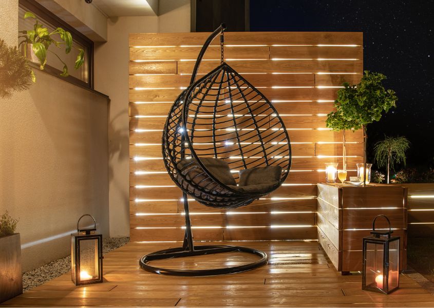 Hanging egg chair at night with outdoor lighting