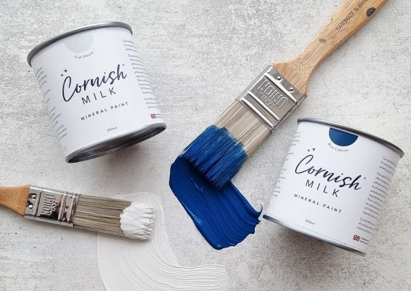 small paint pots with blue paint and brush