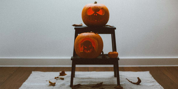 Carved pumpkins on wooden dining chair in hallway