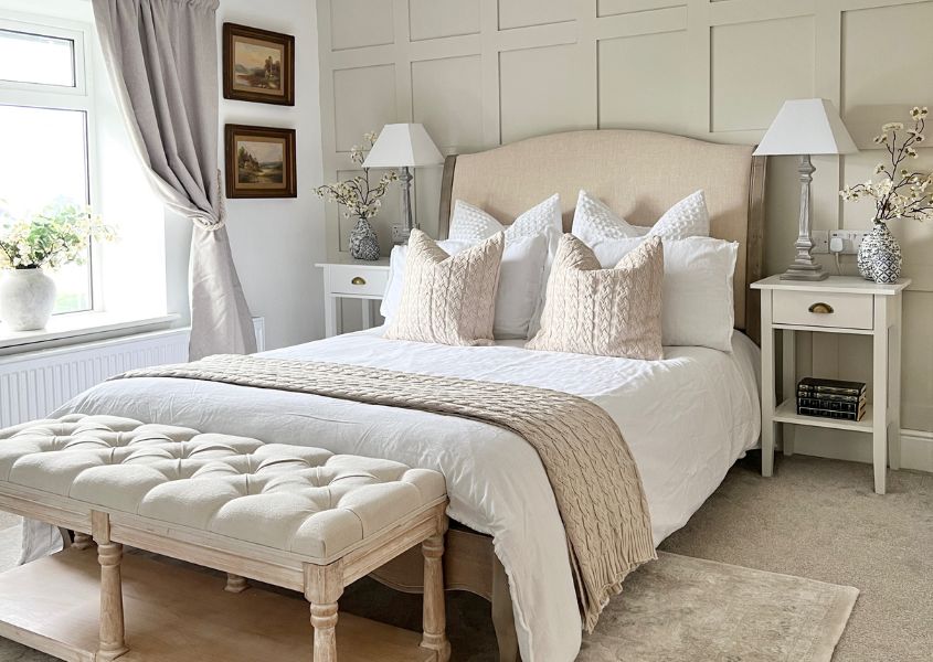bedroom with cream fabric headboard and upholstered bench at foot of bed