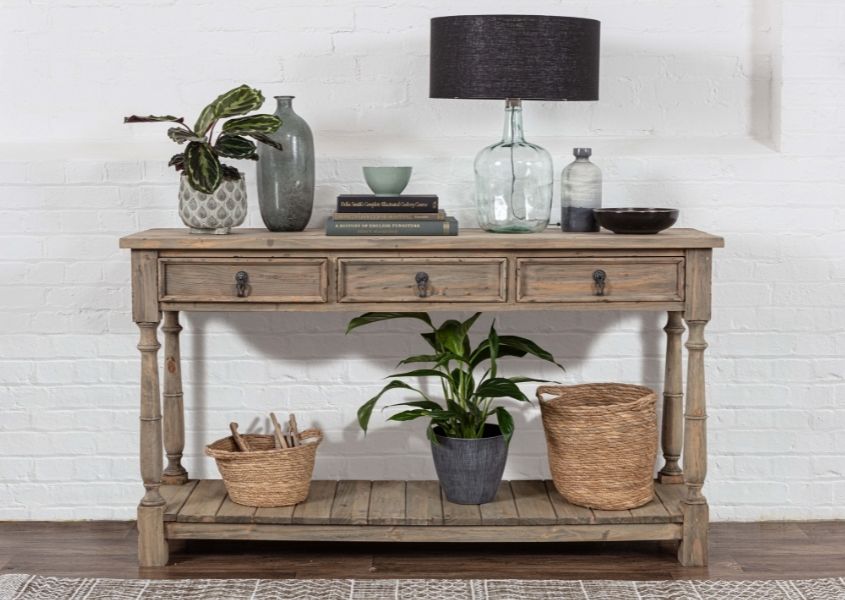 reclaimed wood console table with glass lamp and houseplants