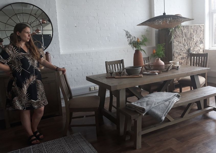 Women standing at a photo shoot of a reclaimed wood dining table and bench