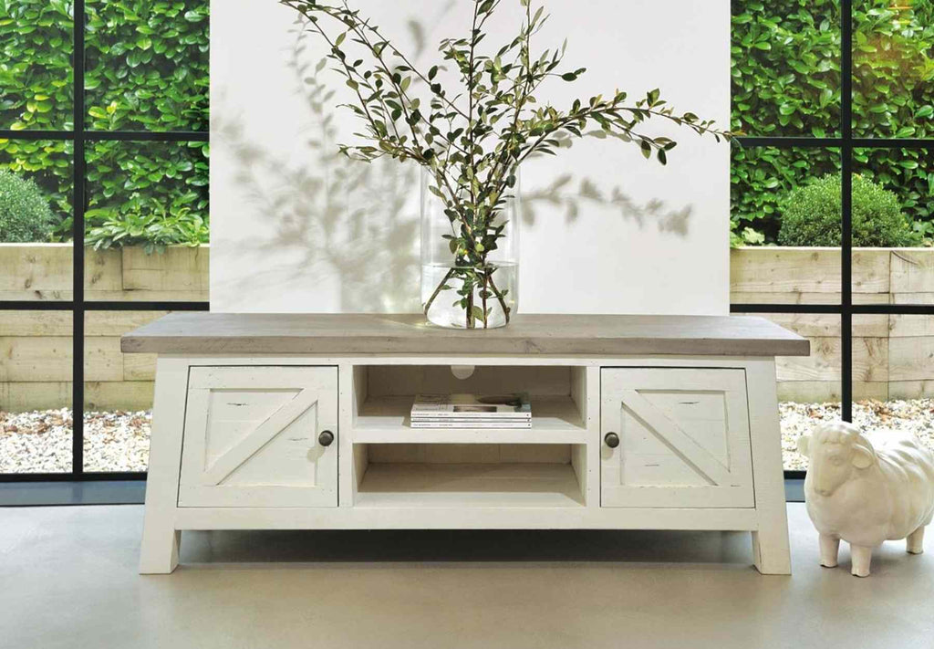 White reclaimed wood tv stand with cupboards and large green plant on top