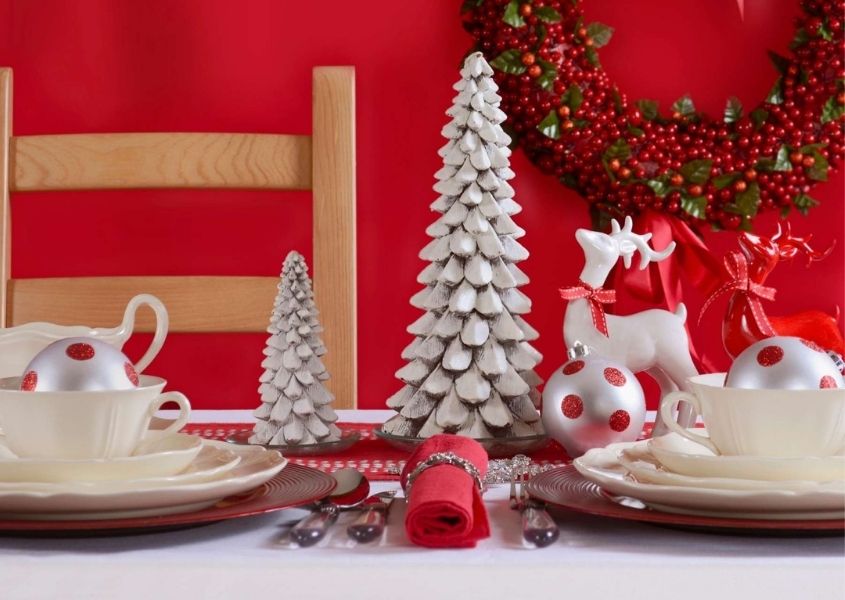 Christmas dining table with red background and white christmas tree decorations