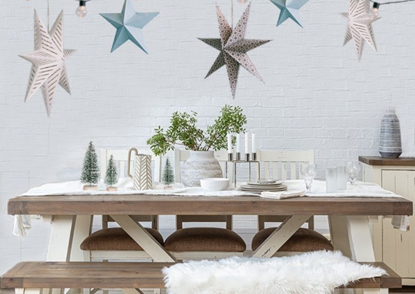 White reclaimed wood dining table with hanging christmas stars