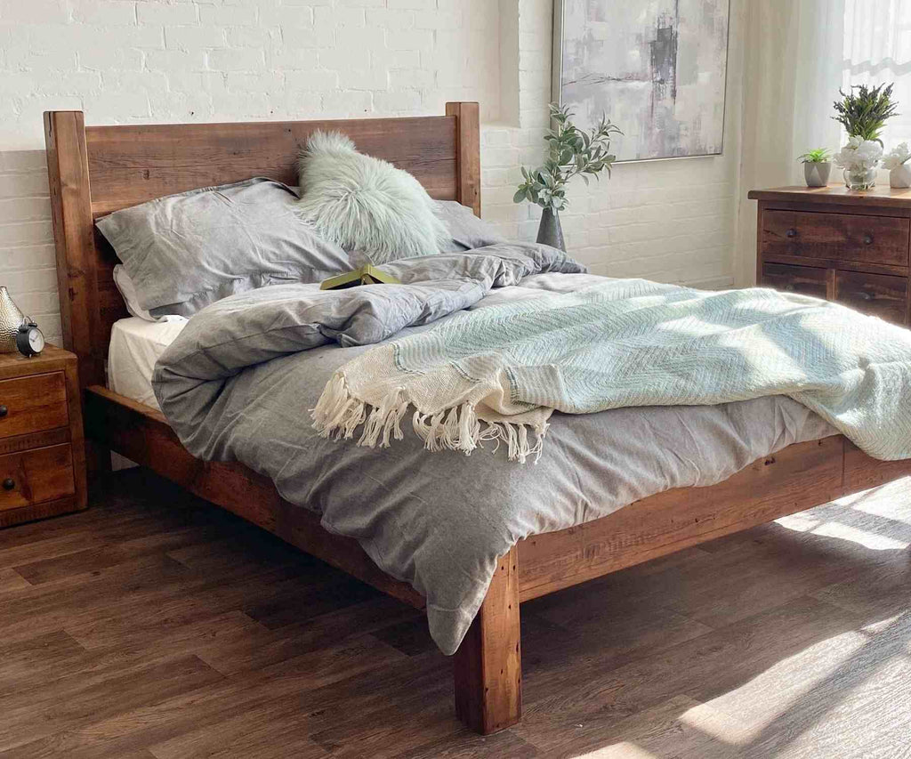 Reclaimed wood bed with grey bed covers and white cushions