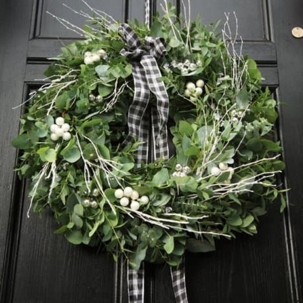 Green and blue Christmas wreath on dark grey front door