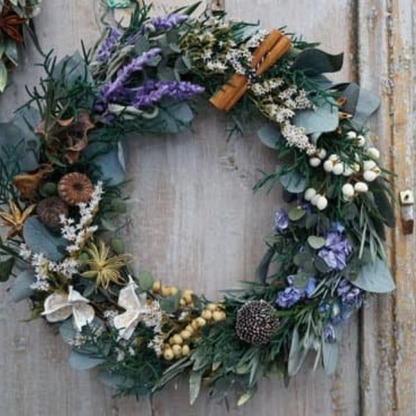Rustic Christmas wreath with dried blue flowers, cinnamon stick and leaves