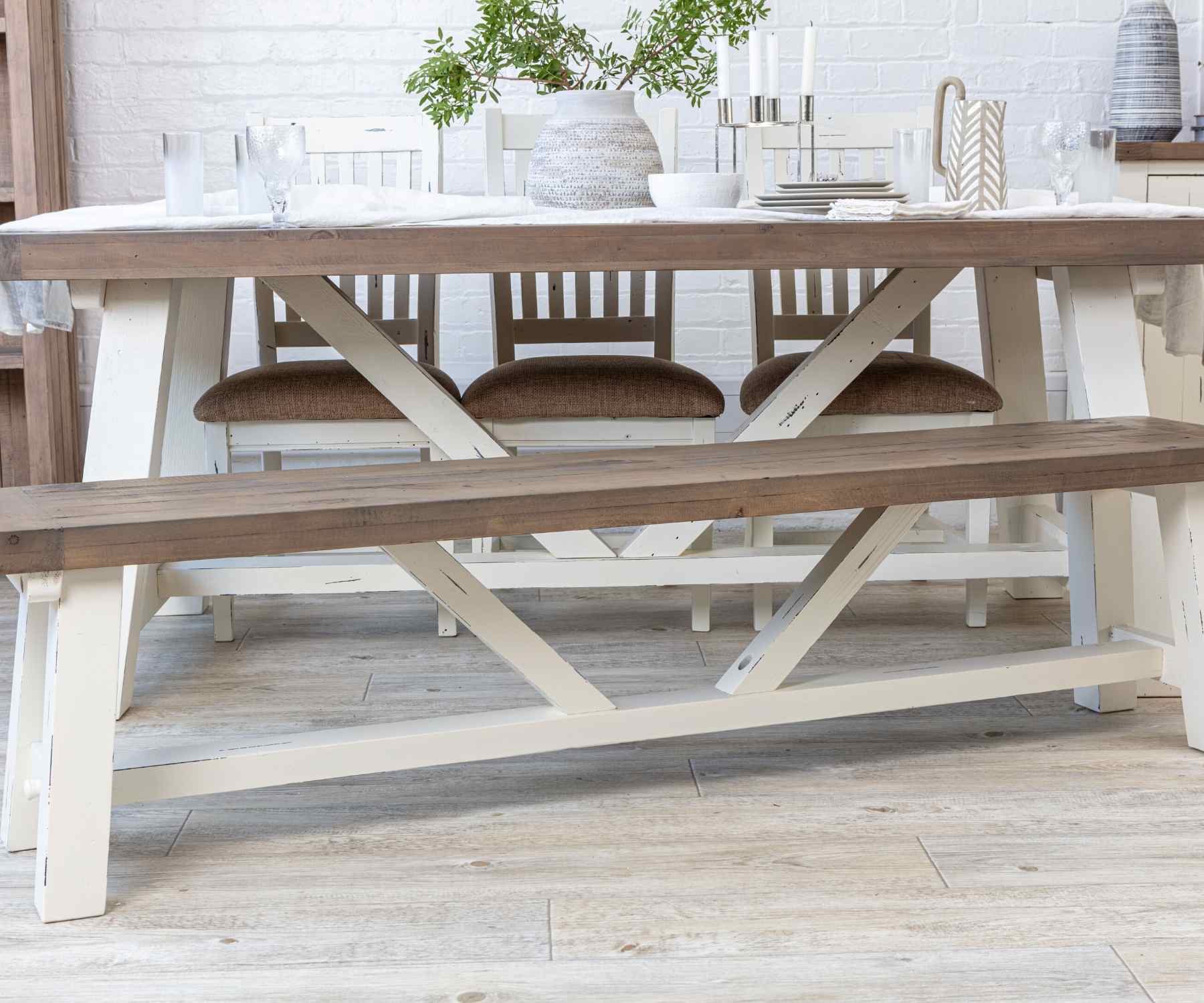 Reclaimed wood dining table with white trestle legs and matching wood bench
