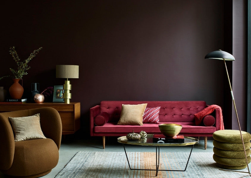 red fabric sofa against a dark painted wall