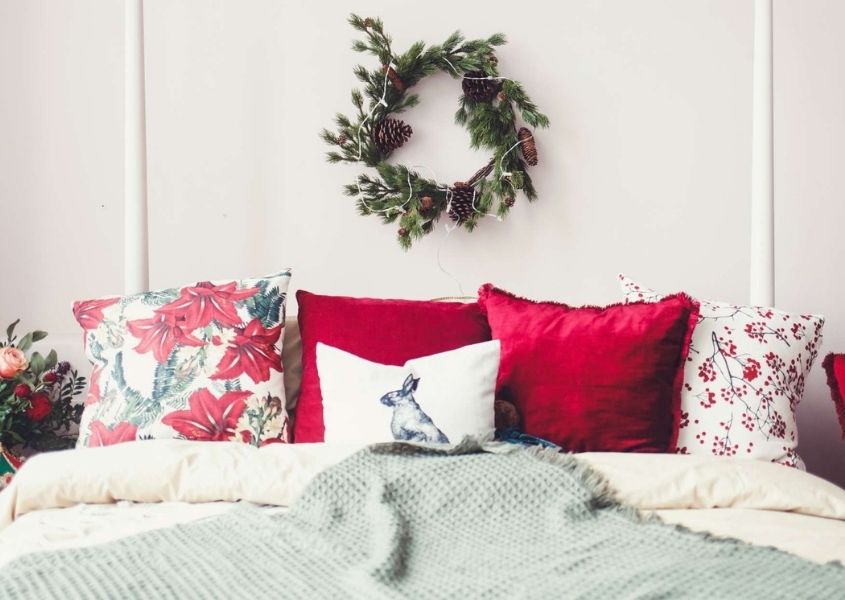 king size bed with Christmas style cushions and Christmas wreath on wall
