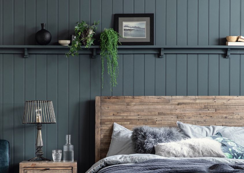 Dark grey wood panelling and solid wood bed for how to create a farmhouse bedroom