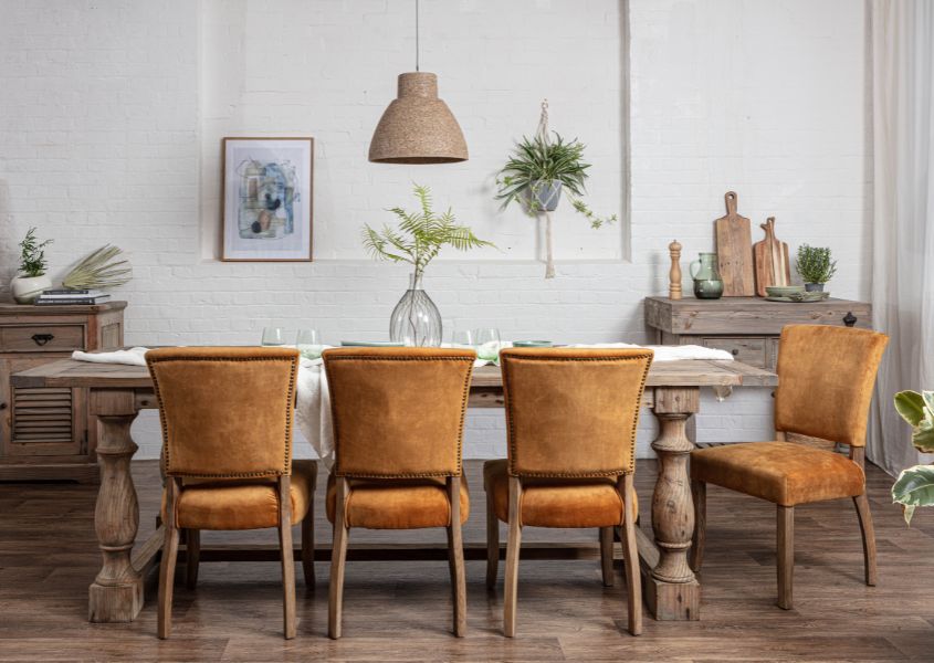 velvet dining chairs in orange around a reclaimed wood dining table