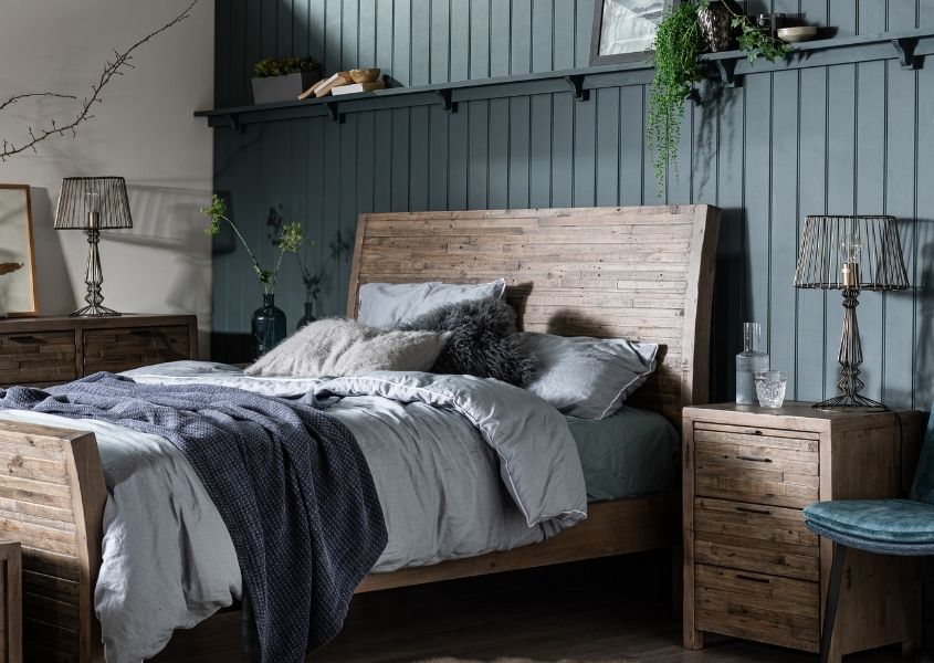 solid wooden bed with dark blue painted wood panelling