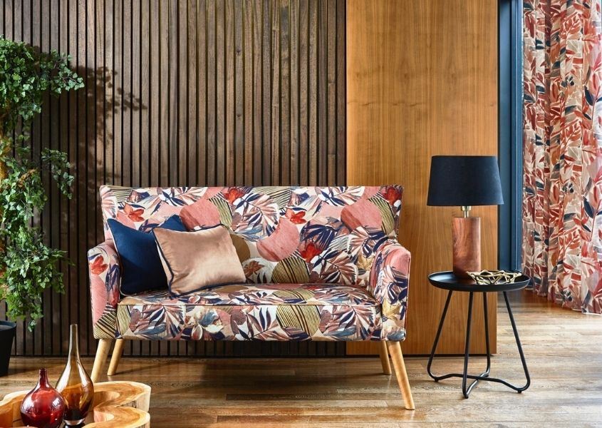 Patterned fabric sofa with wood panelled wall