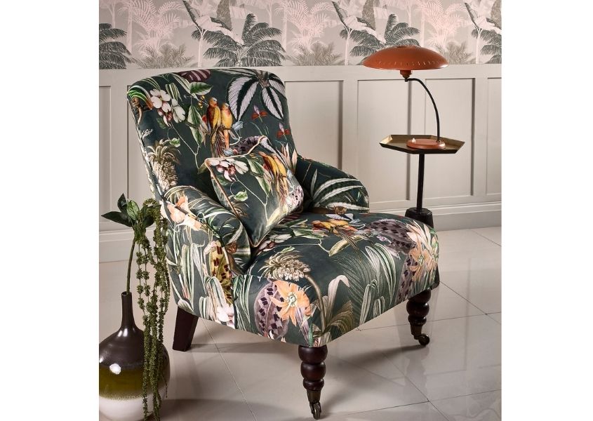 Tropical patterned fabric armchair with palm print wallpaper