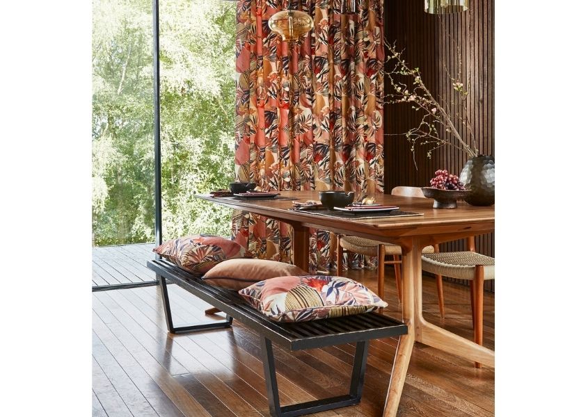 Rustic dining table with metal dining bench and red patterned curtains