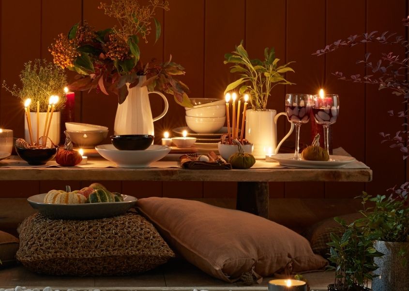 rustic dining table with autumn foods and candles