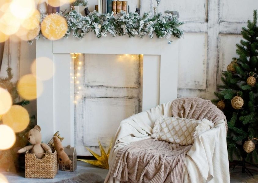 White mantelpiece with Christmas wreath decoration and white armchair