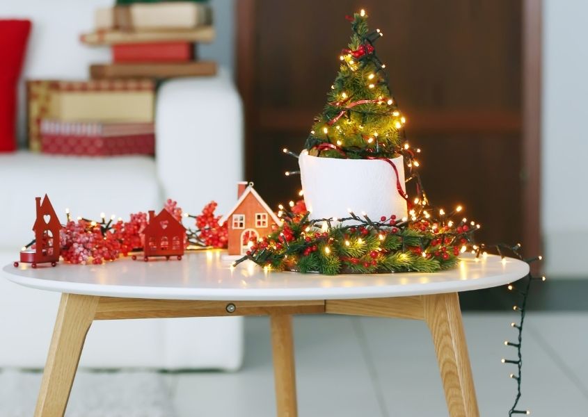 Small Christmas tree on white wooden coffee table