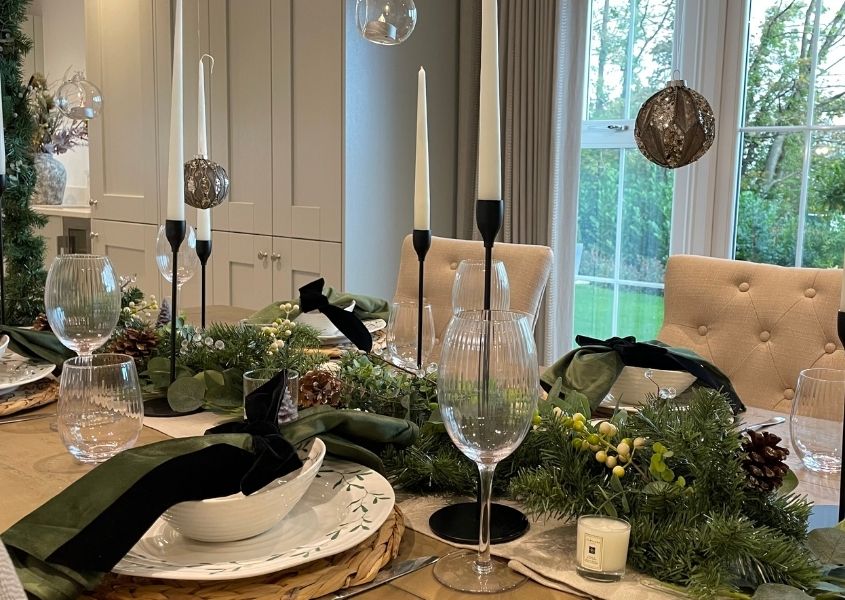rustic dining table with Christmas garland and black candlesticks