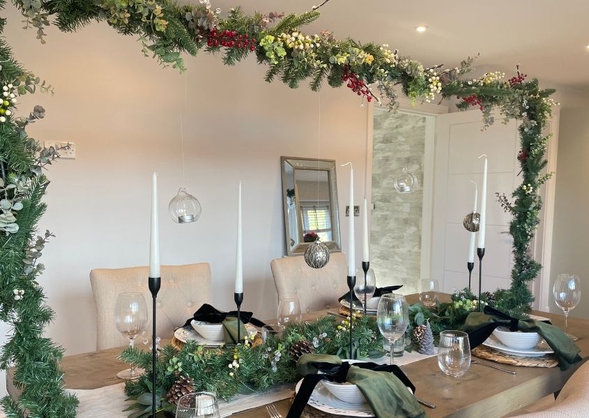 rustic dining table decorated with Christmas hanging rail and table decorations