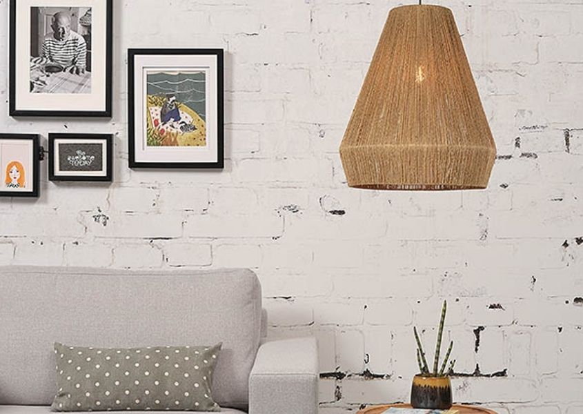 Jute hanging pendant light over side table next to a grey sofa