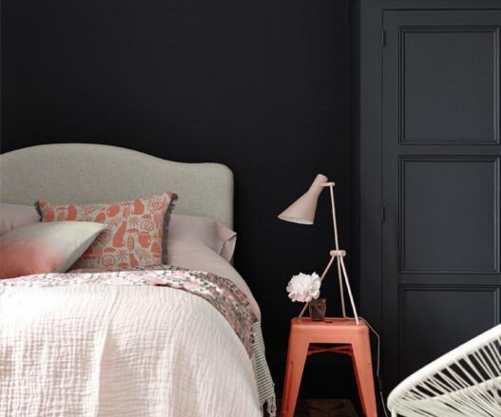 Bedroom with dark grey walls and pink bed covers