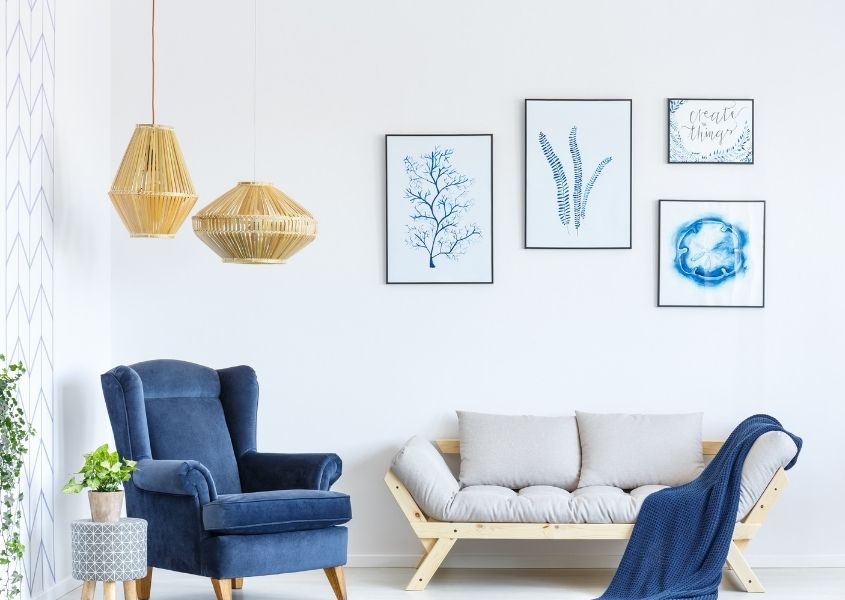 Natural hanging pendant lights in living room with bright blue wing back armchair and light grey sofa