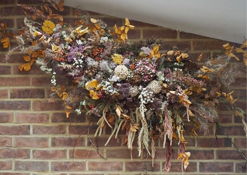 Large dried flower art installation against exposed brick wall