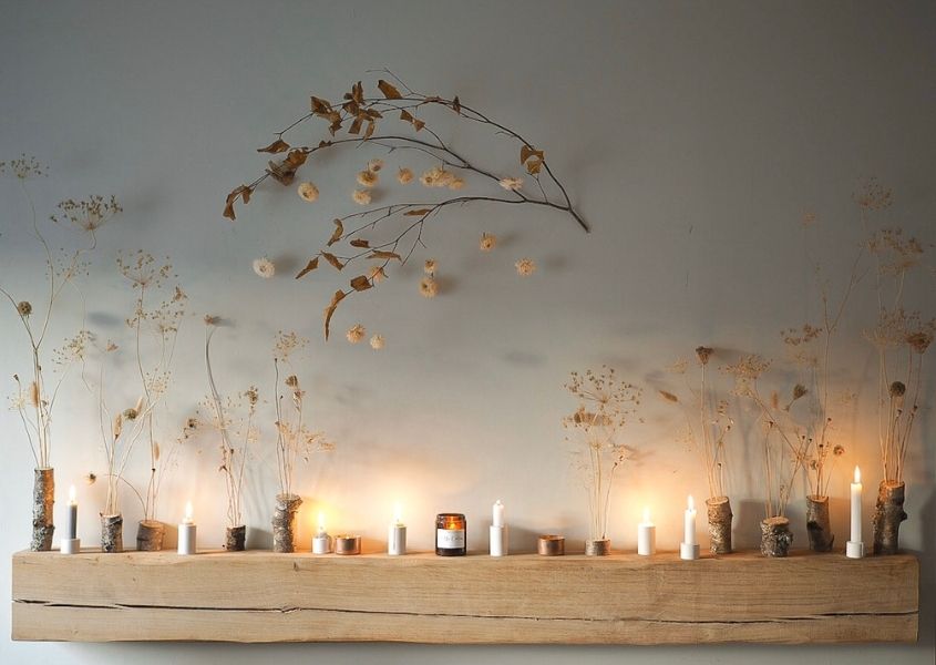 Wooden mantlepiece with arrangement of dried flowers and tea lights