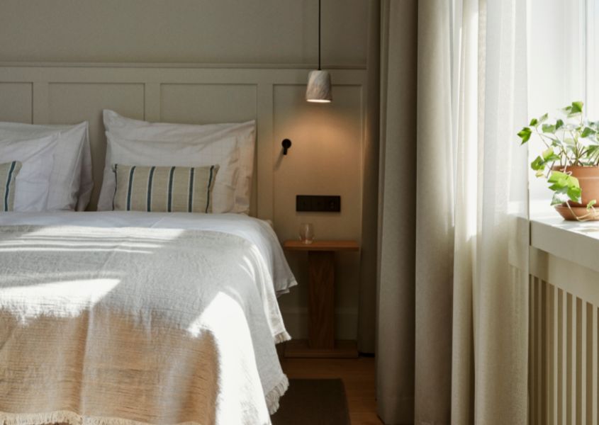 bedroom at Runo hotel with hanging pendant light and wooden bedside table