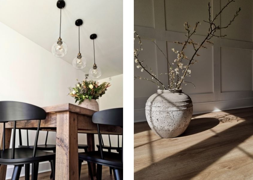 Rustic dining table with three hanging pendant lights, black wood dining chairs and white stone vase