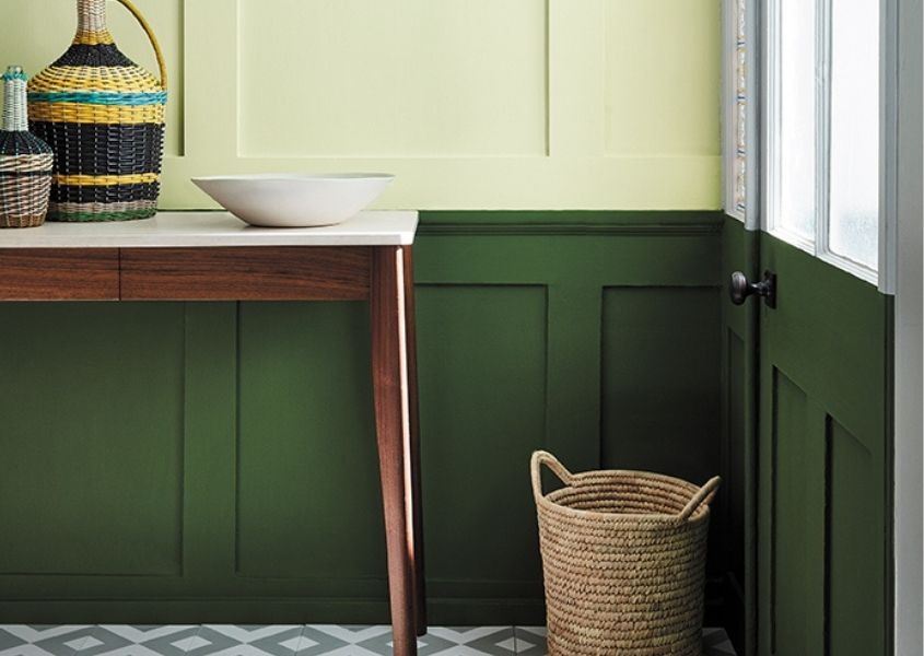 Hallway with dark green painted wood panelling and wooden console table