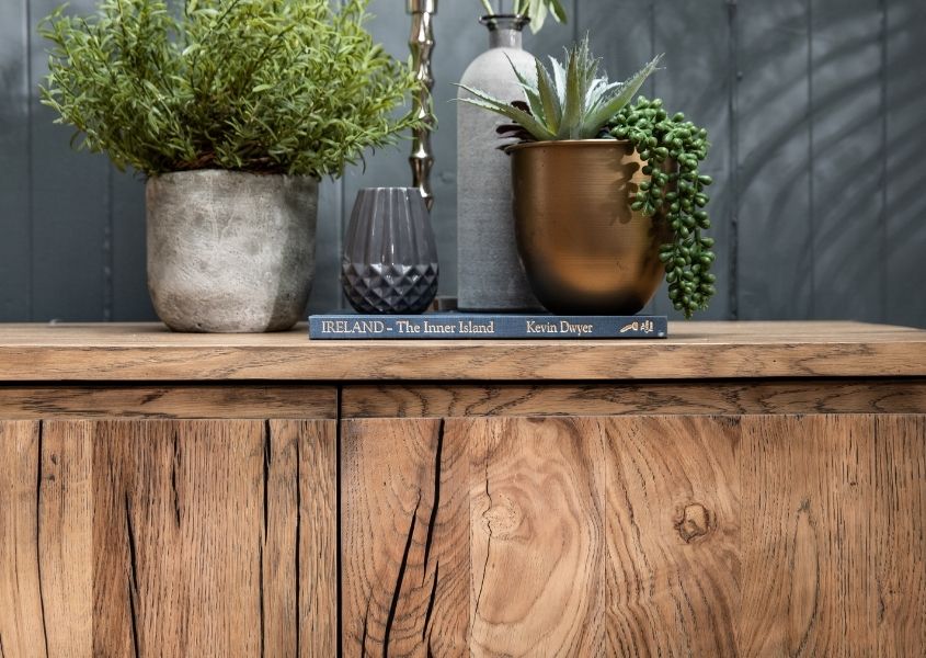 Close up of reclaimed wood furniture with green plants on top