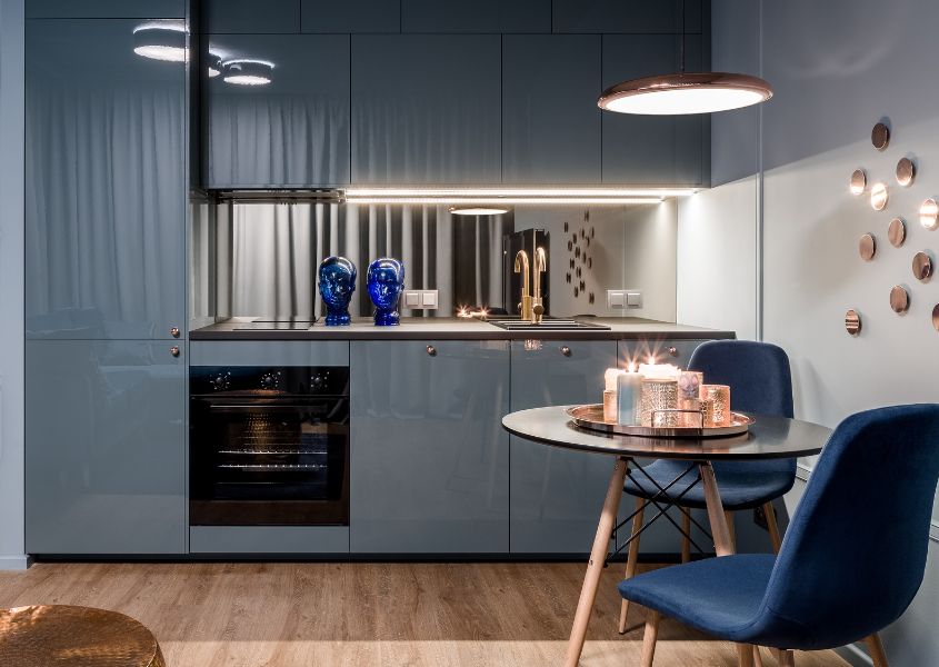 blue kitchen with small round table and blue dining chairs