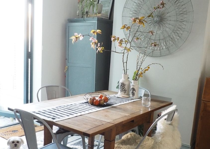 rustic dining table with blue metal dining chairs and blue wooden sideboard