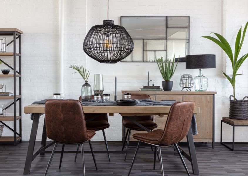 industrial dining table with brown faux leather dining chairs and black rattan hanging pendant light