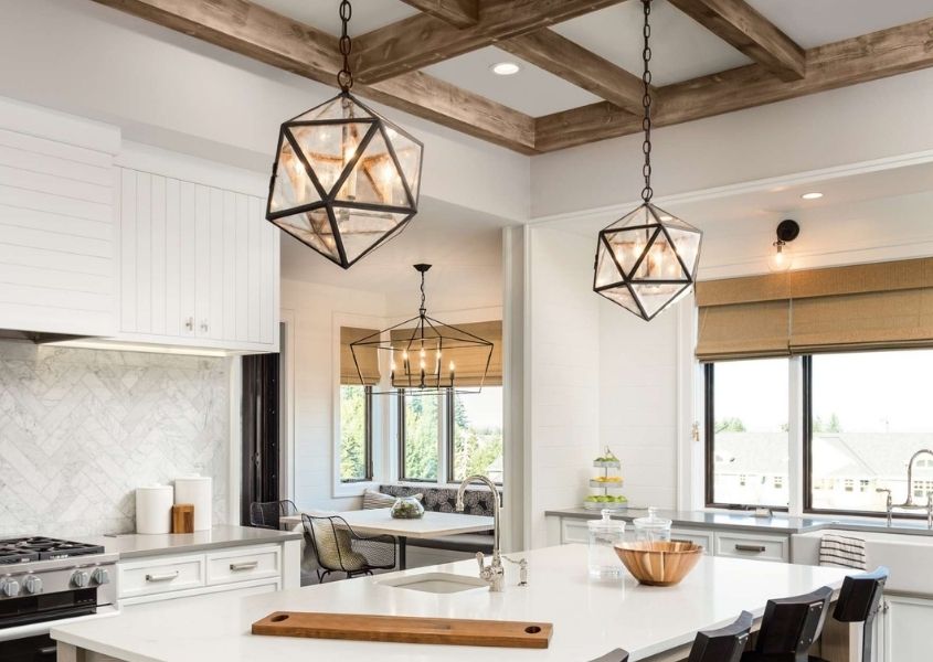 Rustic kitchen with two metal framed hanging pendant lights over breakfast island