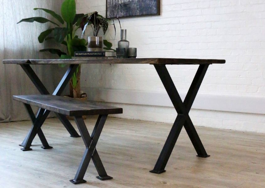 reclaimed wood dining table with cross shaped black metal legs and matching wooden dining bench