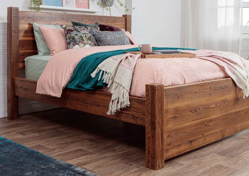 reclaimed wooden bed frame with pink covers